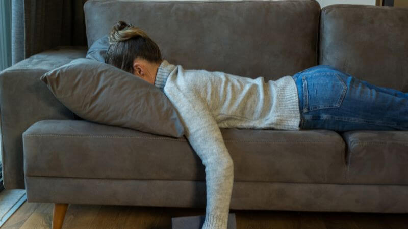 疲れてソファで寝る女性